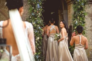 Bride and bridesmaids waiting to enter the church at a Babington House wedding in Somerset