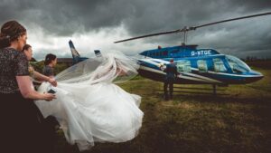 Bride and groom head for the helicopter at an Orchardleigh House wedding in Somerset