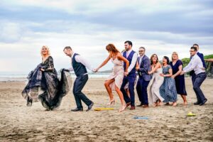 Bride, groom and guests dancing on the beach at a wedding at Harry's Shack in Portstewart Northern Ireland