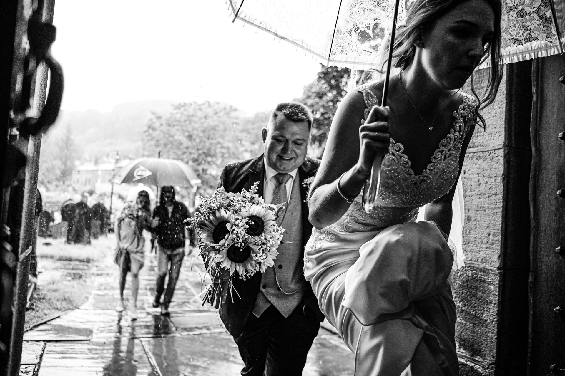 Bride arrives at the church at a rainy wedding in Lancashire