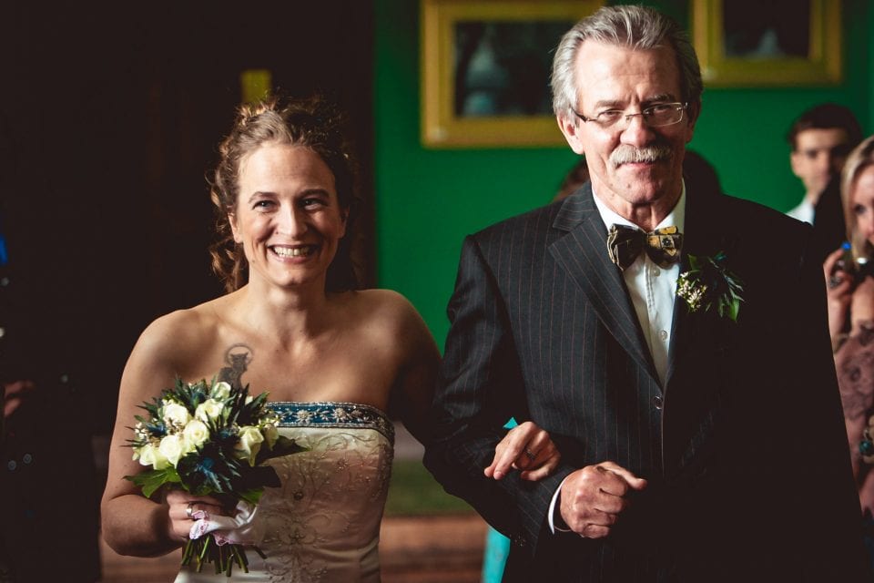 Bride and father walking down the aisle at a Carbisdale Castle wedding in Scotland