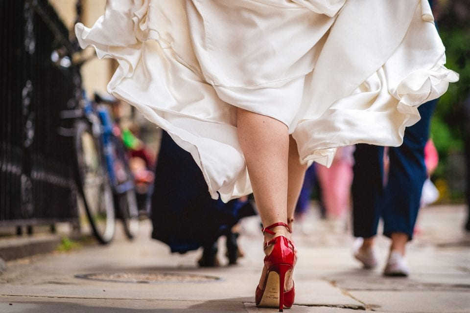 Bride in red Jimmy Choo shoes walking to her Oxford wedding venue