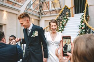 Bride and groom enter the wedding breakfast at a wedding at Botleys Mansion in Surrey