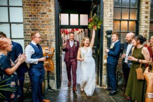 Wedding couple walk into the venue at a MC Motors wedding in London