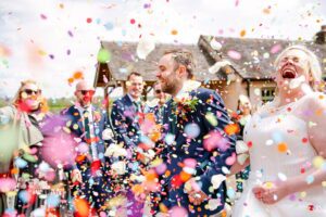 Confetti shower with smiling bride at the Ashes Barns wedding venue in Staffordshire.