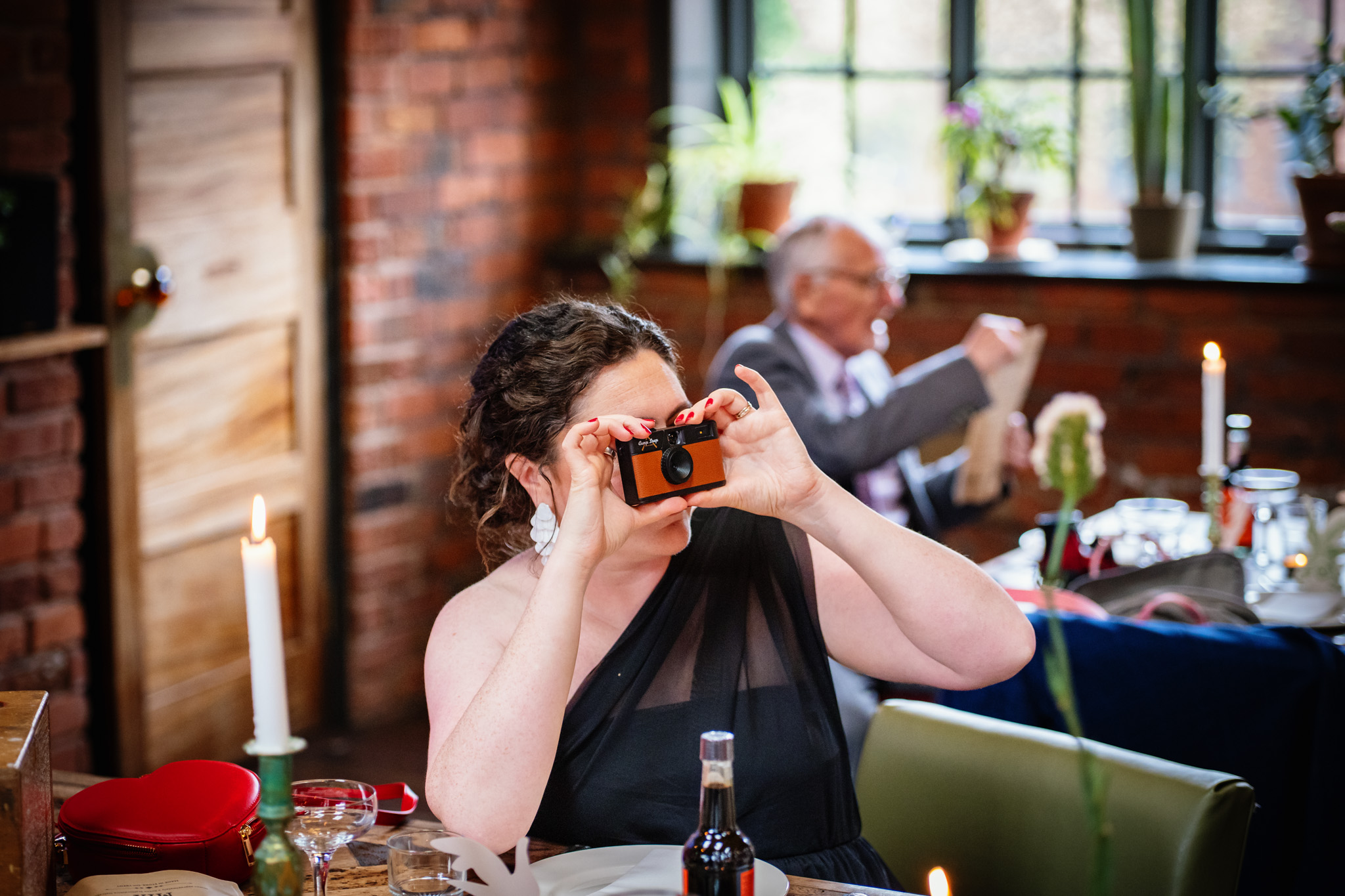 Guest takes a photo at a relaxed Chimney House wedding in Sheffield