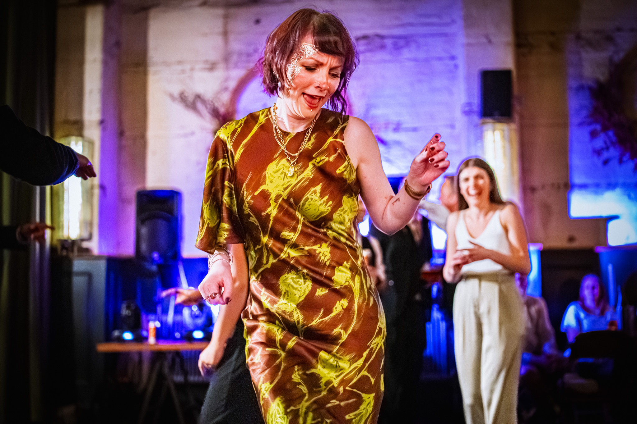 Woman dancing in a green dress at a wedding reception at The Mowbray in Sheffield