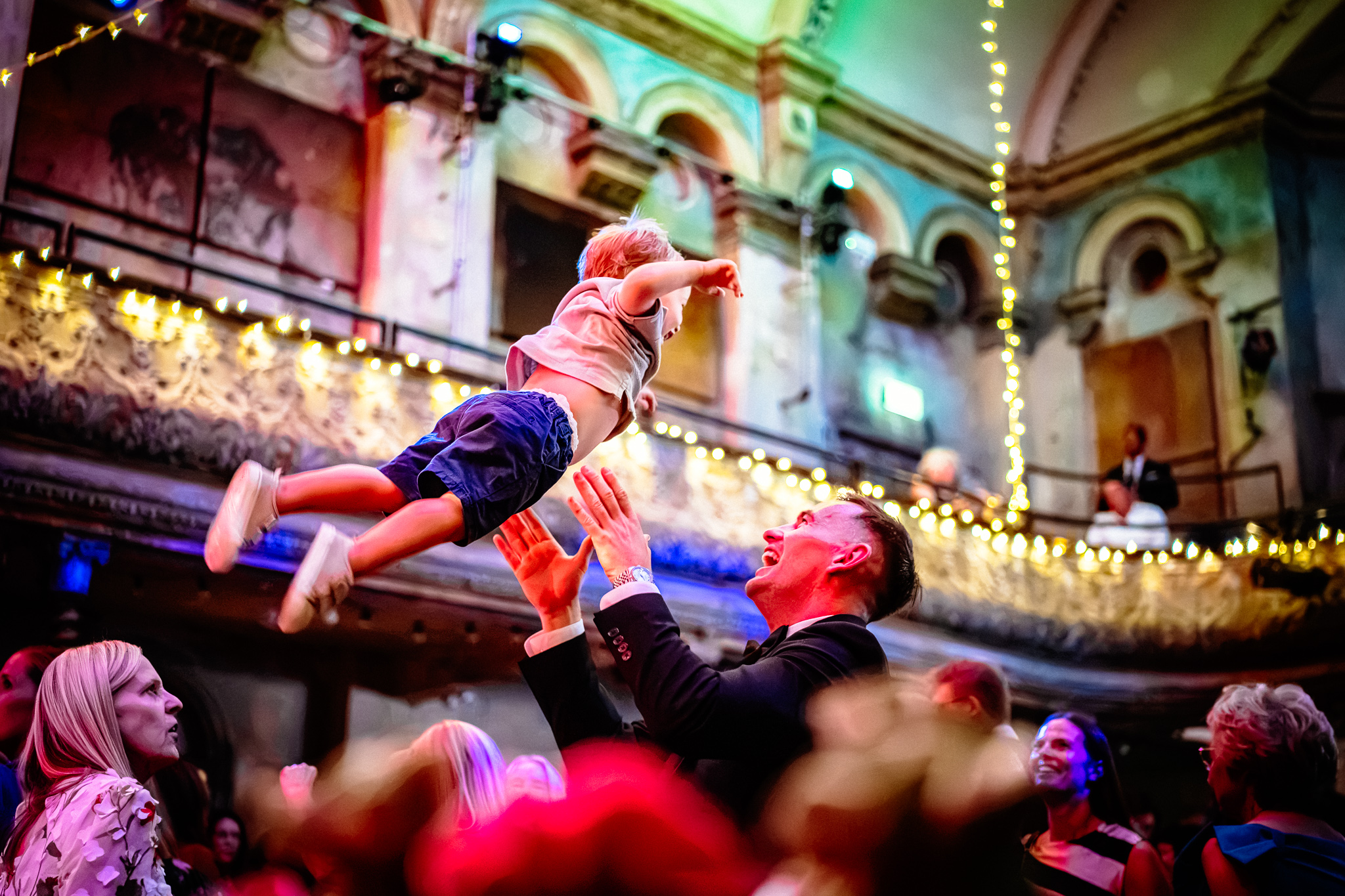 Man throwing baby in the air on a dance floor
